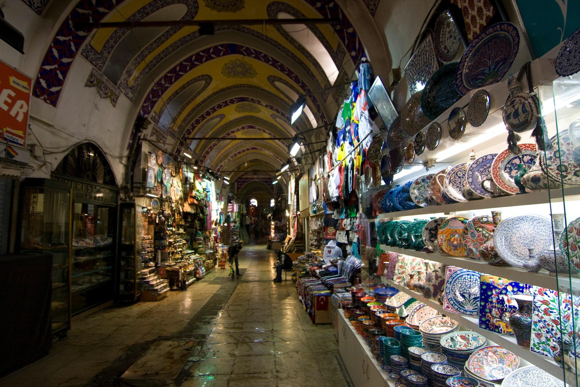 The painted vaulted arcade of the Grand Bazaar, ceramics stacked along one side