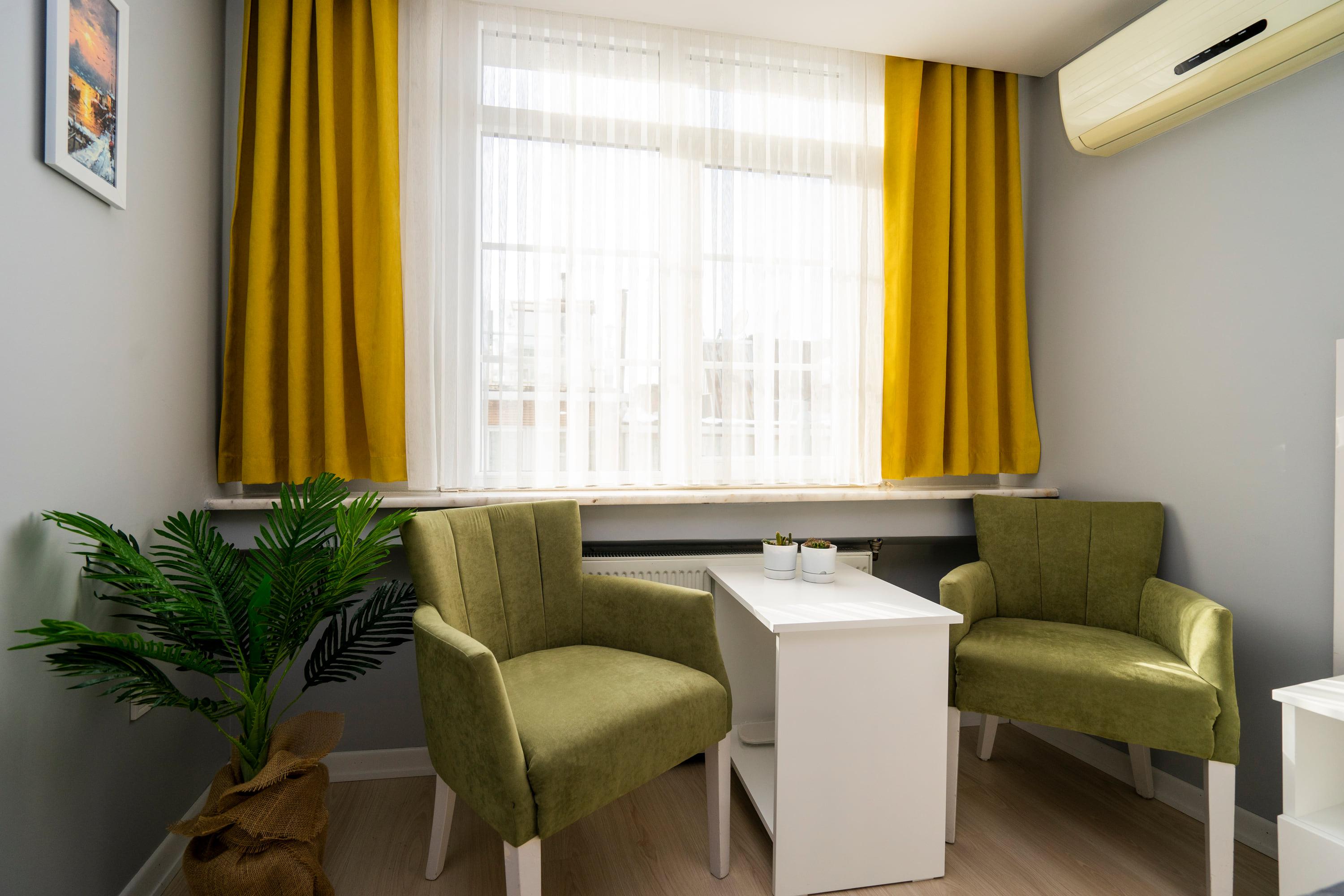 Two armchairs and a white table at the window
